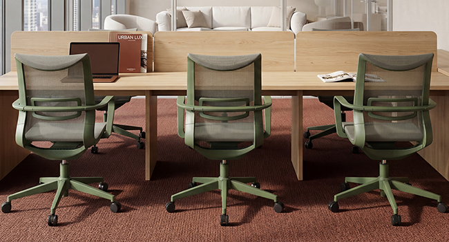 Intérieur de bureau moderne présentant trois chaises de travail en maille verte avec des cadres en bois disposés autour d'une table de conférence en bois clair. Espace de travail contemporain avec éclairage naturel et parquet.