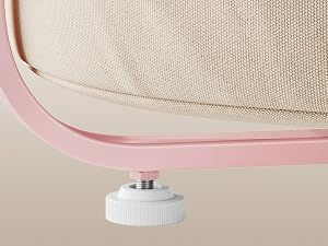 Detalle detallado de la esquina de una silla que muestra una tapicería de tela beige con ribete rosa y un pie ajustable blanco