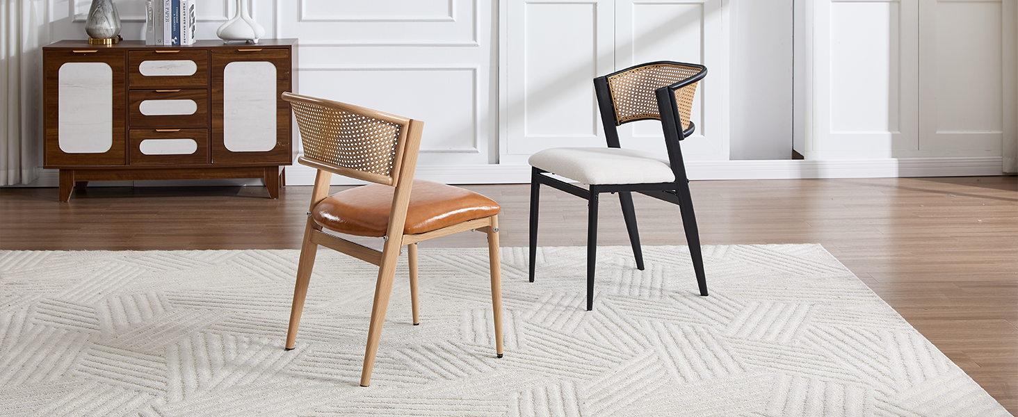 Modern living room setting with two chairs - one natural wood with woven cane back, one black - positioned on white rug with wooden sideboard in background.