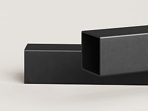 Two matte black rectangular blocks arranged in perpendicular configuration against light gray background, creating geometric composition.