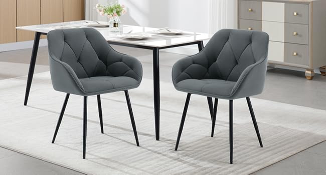 Set da pranzo moderno con tavolo rotondo bianco e due sedie imbottite grigie. Pavimento in legno chiaro e mobile bianco visibile sullo sfondo