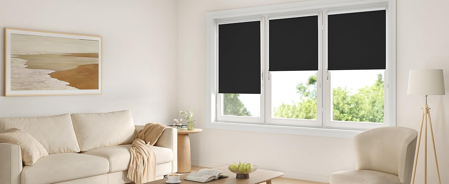 Espacio interior moderno con persianas enrollables de color crema en varias ventanas, que crean una estética brillante y minimalista contra las paredes blancas.