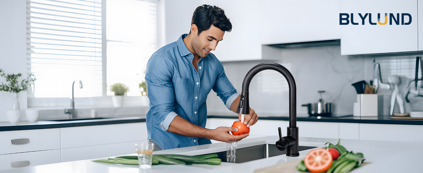Modern black kitchen faucet shown in use with water running, appears to be a Blylund brand product in contemporary kitchen setting.