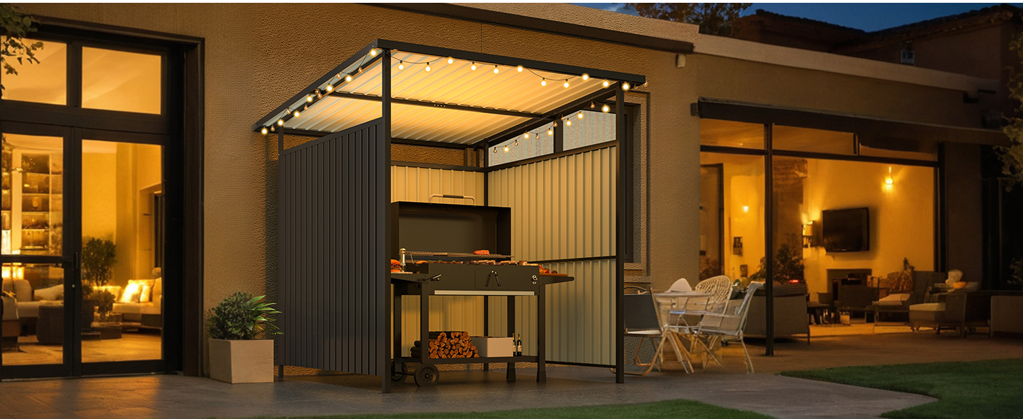 Kochpavillon für den Außenbereich mit Metallrahmen, Leinendach und eingebautem Grill. Verfügt über LED-Beleuchtung und befindet sich auf einer Terrasse in der Nähe eines warm beleuchteten Innenraums