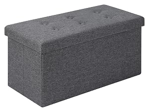 Pouf o panca portaoggetti rettangolare in tessuto testurizzato grigio scuro, caratterizzato da un design con coperchio a cerniera.