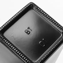 Vue rapprochée d'un composant d'appareil noir de forme carrée avec des bordures striées texturées et une