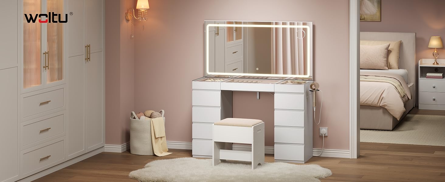 Modern white bedroom furniture set featuring dresser with mirror, nightstand, and bed frame in contemporary interior with warm lighting and beige accents.