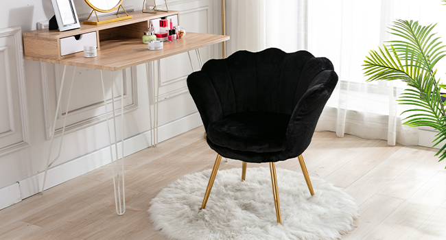 Modernes Home-Office-Setup mit einem an der Wand montierten Holzschreibtisch, einem schwarzen Samtstuhl und einer Topfpflanze auf einem hellen Boden