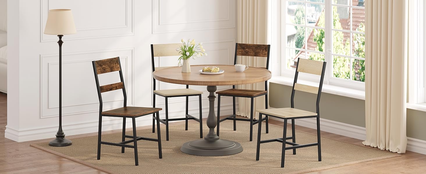 Rustic dining set featuring wooden chairs and round table in bright white room with large window and floor-length curtains.
