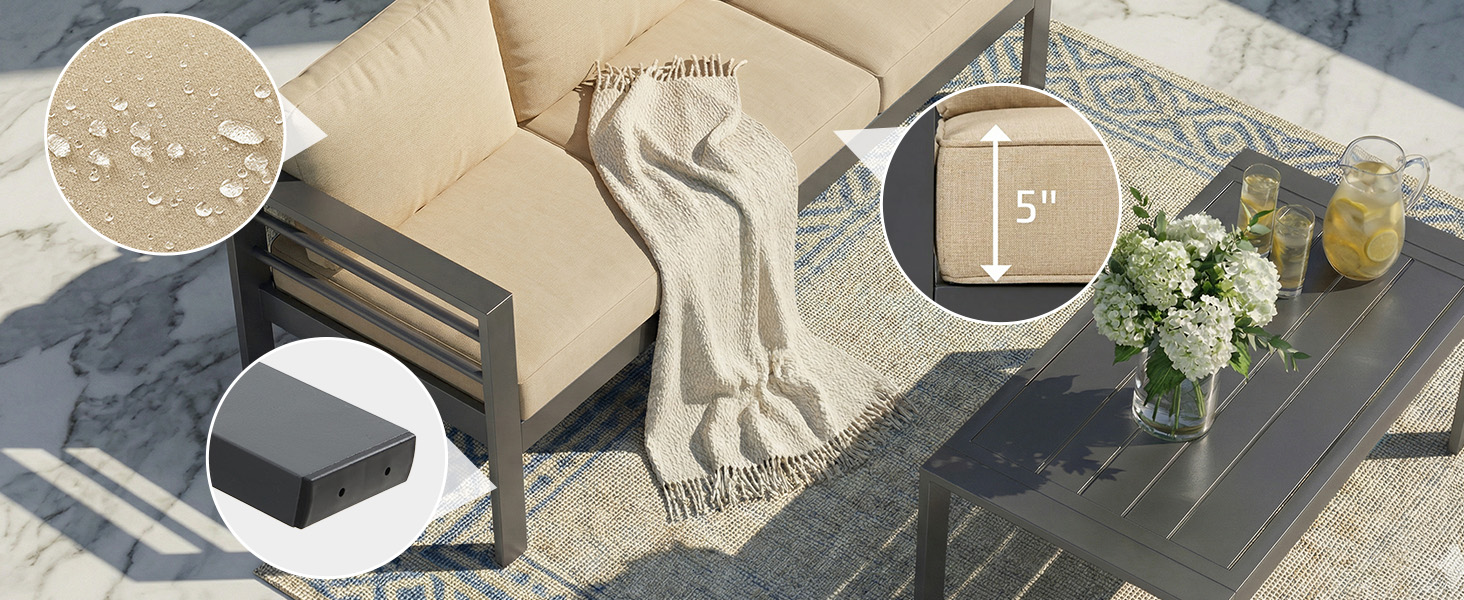 Overhead flat lay composition on textured gray surface featuring: white fabric, cosmetic or beauty items in black/dark packaging, decorative elements including white flowers and foliage, arranged artistically for product display.