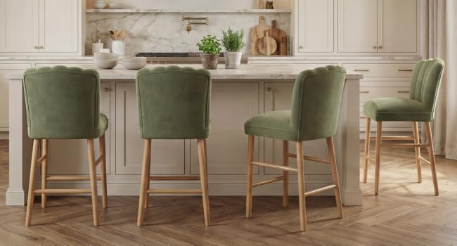 Ensemble de salle à manger moderne comprenant une table blanche et quatre chaises rembourrées vertes avec des pieds en bois naturel dans un espace intérieur clair et contemporain avec un décor neutre.