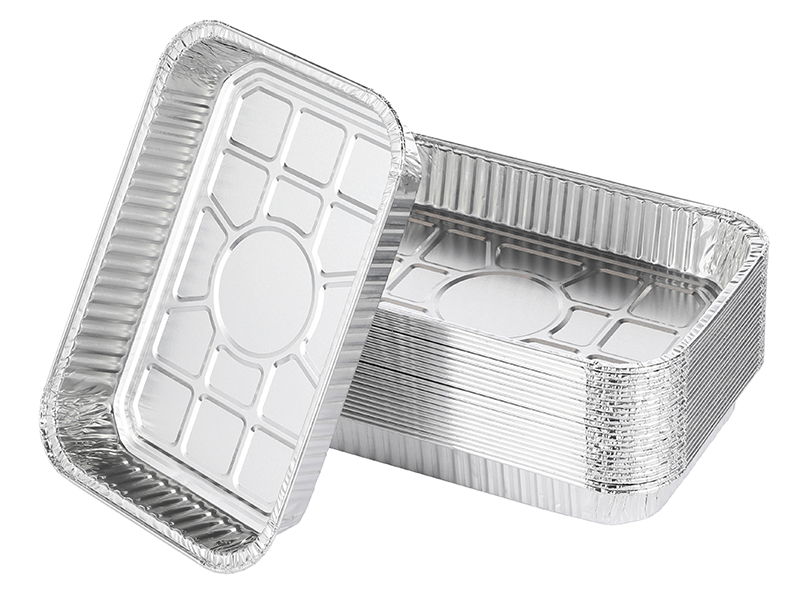 Pile de contenants rectangulaires en aluminium avec côtés nervurés et fonds sectionnés. Plateaux jetables pour le stockage des aliments ou la cuisson.