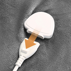 Support ou appareil de recharge sans fil blanc présenté sous plusieurs angles sur une surface texturée foncée, avec une bande décorative dorée ou cuivrée.