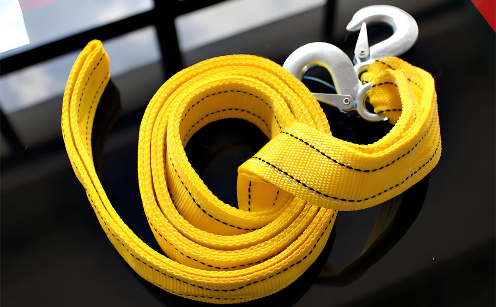 Yellow heavy-duty tow strap or recovery strap coiled against dark background.