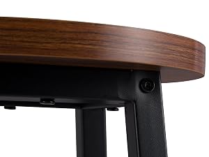 Close-up of a round wooden table top with visible grain, attached to black metal legs or frame.