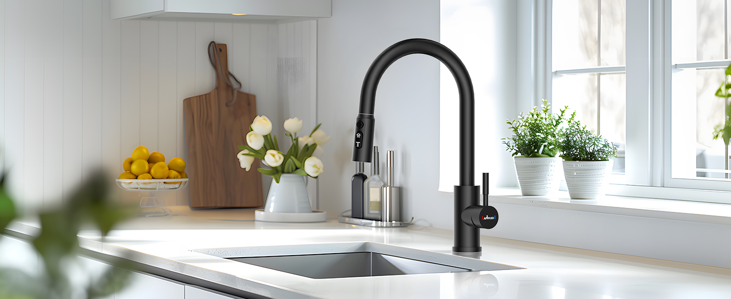 Modern black gooseneck kitchen faucet with pull-down sprayer, installed in white sink near sunny window with decorative plants and cutting boards.
