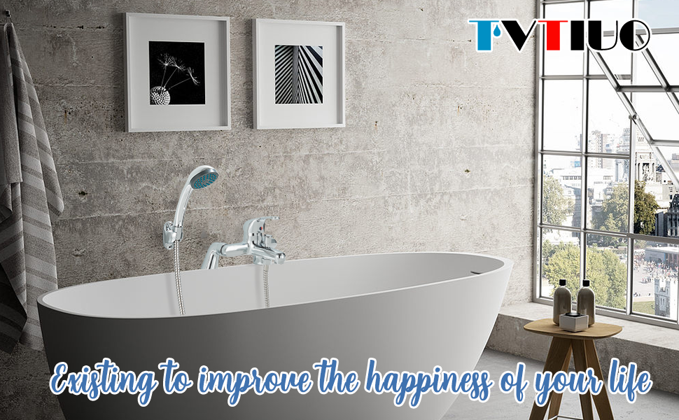 Modern freestanding white bathtub in a minimalist bathroom with concrete walls, large window, and framed artwork. Brand 'IVITILO' visible.