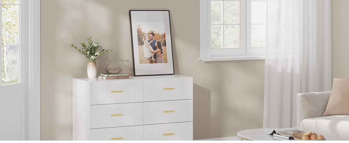 Spazio interno luminoso e minimalista con pareti bianche, che mostra elementi decorativi e disposizioni di mobili.