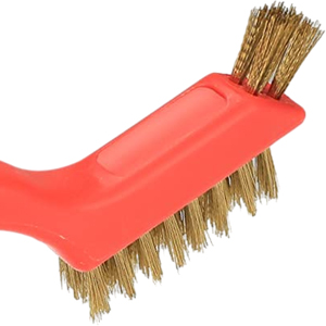 Close-up of a red plastic scrub brush with natural bristles, showing angled handle design and dense bristle arrangement.