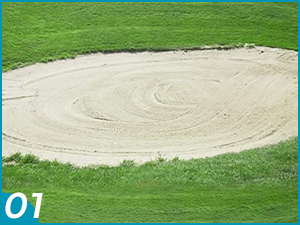 Bunker à sable circulaire sur un terreno de golf, con un motivo en espiral creusé dans le sable. Le bunker est entouré de gazon vert soigneusement taillé