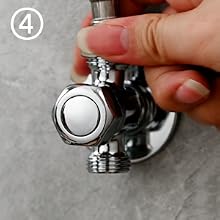 Primer plano de un desviador de ducha circular de metal con acabado cromado, que muestra la instalación o el ajuste en progreso