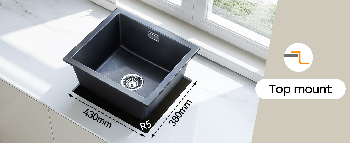 Black rectangular kitchen sink with dimensions 430mm x 390mm. Top-mount installation style indicated. Sink features a circular drain and is set in a white countertop near a window.