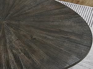 Close-up of a round dining table top with dark wood grain pattern radiating from center in a sunburst design.