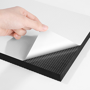 une main touche une feuille de papier avec un carré blanc sur le bord.