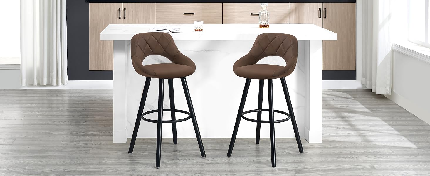 Dos taburetes de bar tapizados en marrón con respaldos curvos y patas de metal negro, colocados en una isla de cocina blanca en un ambiente interior moderno