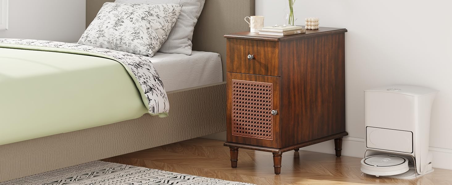 Table de chevet moderne en bois du milieu du siècle avec façade à lattes, placée à côté d'un lit avec une literie florale.