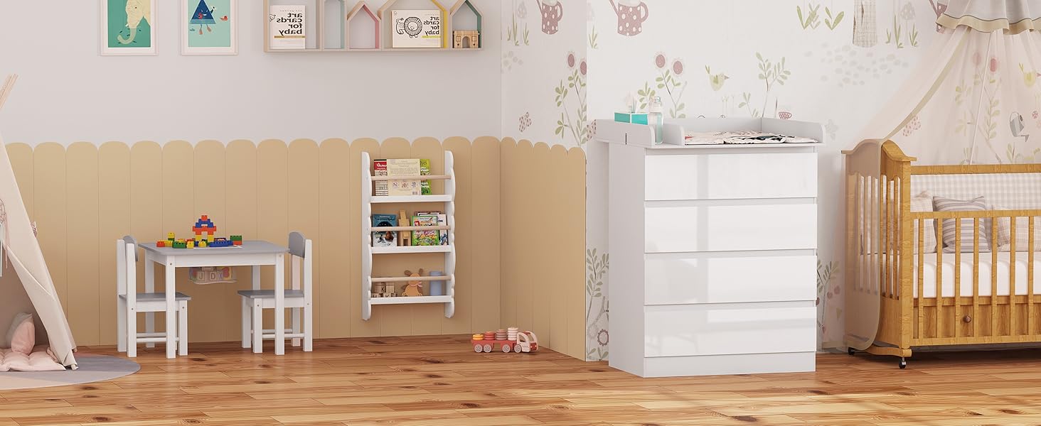 Nursery furniture set including wooden crib, white chest of drawers, small table with chairs, and bookshelf. Neutral tones with colorful wall decorations.