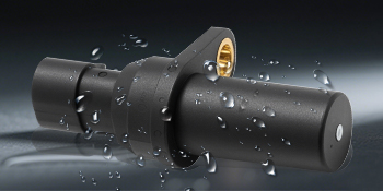 Black industrial equipment or machinery parts with water droplets or moisture visible on the surface, shown in dark lighting conditions.