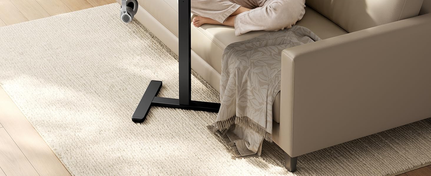 La pata del armazón de la cama con almohadilla ajustable de metal negro se coloca sobre una alfombra beige junto al somier tapizado, lo que demuestra la función de estabilización del mueble.
