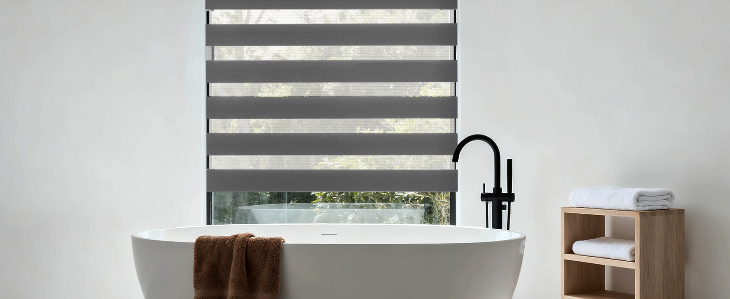 L'intérieur de la salle de bain moderne comprend un abat-jour à rayures grises et blanches, un robinet noir et un comptoir blanc avec une serviette visible et une unité de rangement.