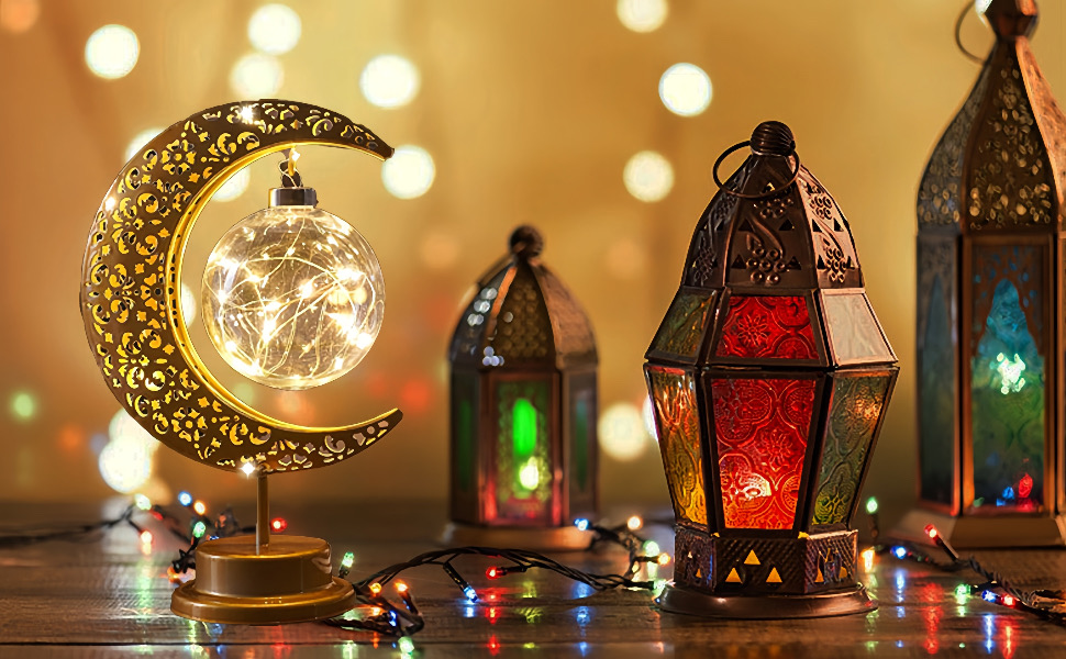 Esposizione di lanterne decorative comprendente un apparecchio di illuminazione a mezzaluna dorata e lanterne multicolori rosse e verdi con luci a stringa che creano un'illuminazione d'ambiente.