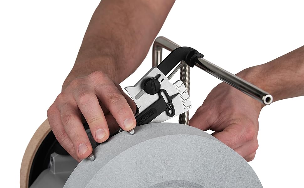 Primo piano di mani che utilizzano uno strumento metallico per affilare una lama circolare o un disco su una mola, a dimostrazione della corretta tecnica di affilatura