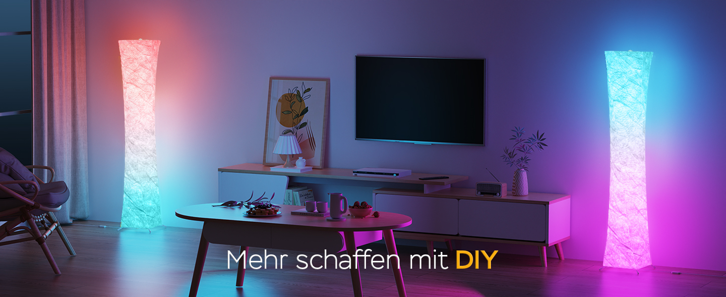 Modernes Wohnzimmer mit zwei hohen, farbwechselnden LED-Stehlampen. Kaffeetisch und TV-Ständer sichtbar. Die Texteinblendung lautet „Mehr schaffen mit