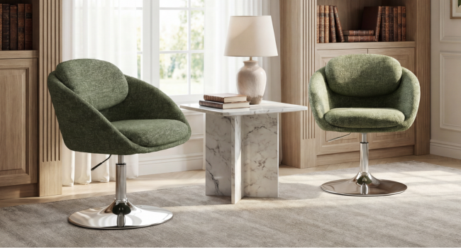 Modern interior featuring pair of curved green upholstered armchairs with chrome swivel bases, white side table between them, floor lamp, wooden flooring, and neutral wall décor.