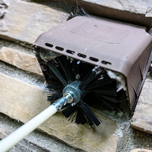 une brosse est utilisée pour nettoyer un mur de briques.