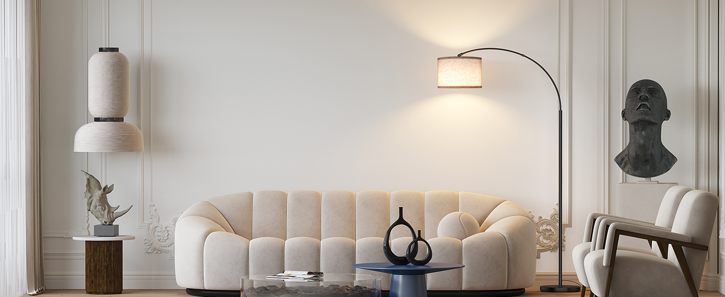 Modernes Wohnzimmer mit cremefarbenem Polstersofa aus Plüsch, gepolsterter Polsterung, dazu eine gewölbte Stehlampe