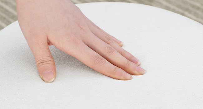 Close-up of woman's hand resting on white surface, showing skin texture and manicure.