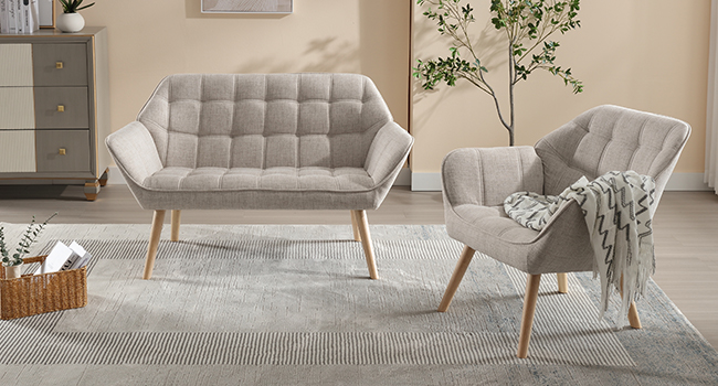Modern living room set featuring a light gray tufted loveseat and matching armchair with wooden legs. Both pieces have a sleek, angular design on a striped area rug.