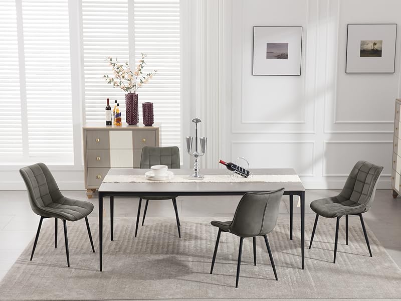 Set da pranzo moderno con tavolo in effetto marmo bianco con gambe in metallo nero e quattro sedie imbottite grigie con schienale trapuntato e strutture