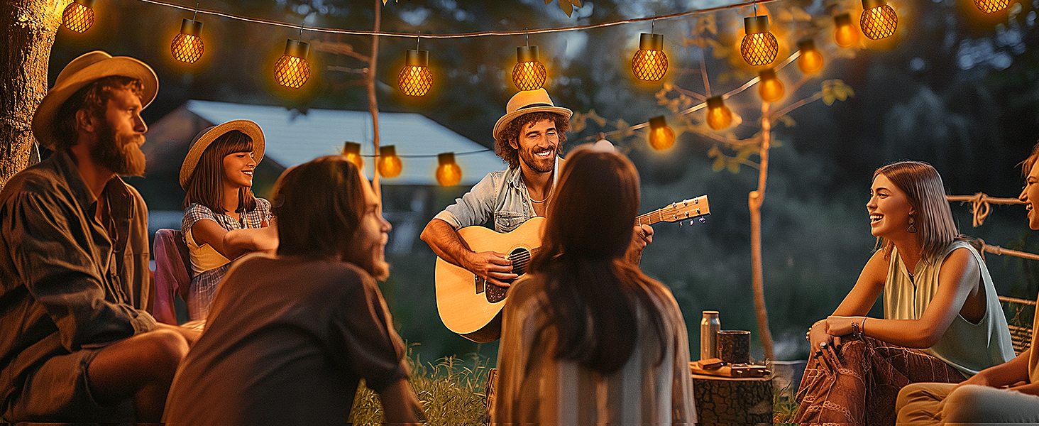 Festa all'aperto con luci a stringa, che mostra persone sedute mentre qualcuno suona la chitarra acustica.