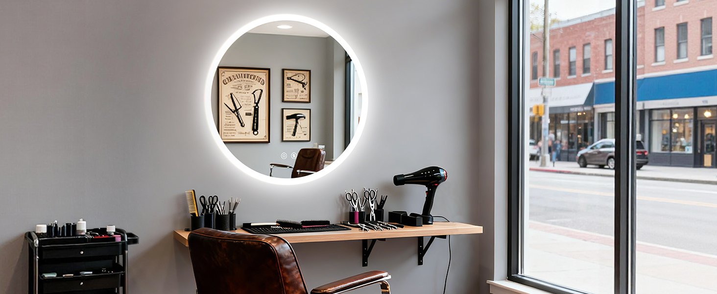Ambiente di lavoro moderno con specchio rotondo illuminato, superficie della scrivania in legno e finestra con vista sul paesaggio urbano. Varie forniture e attrezzature per ufficio visibili.