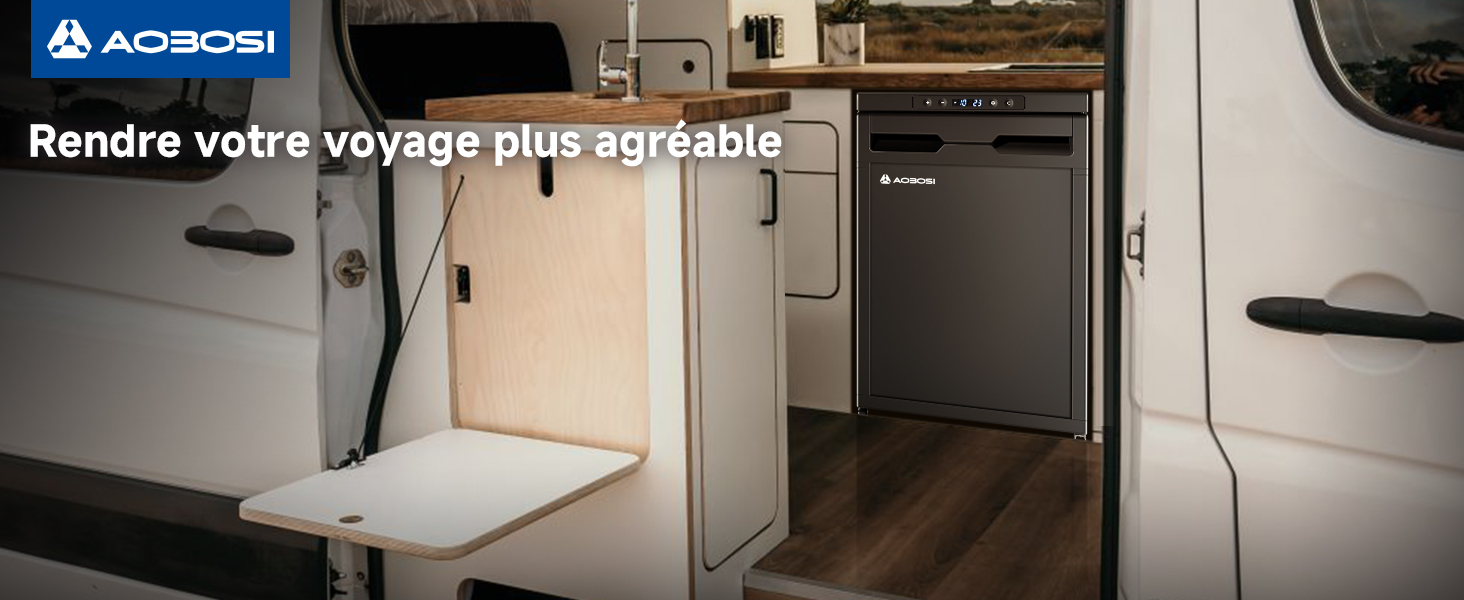 Vue intérieure d'un camping-car montrant une table rabattable attachée à une armoire. La table est en position basse, laissant apparaître une surface blanche. Plancher d'aspect bois visible en arrière-plan
