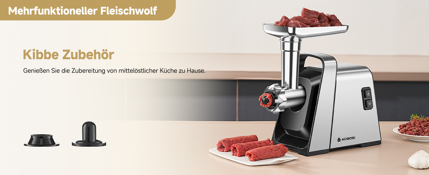 Elektrischer Fleischwolf mit Edelstahlgehäuse und Zubehör. Zeigt rohe Fleischwürfel auf der oberen Platte und Hackfleisch auf der Seitenplatte. Zusätzliche Anlagen sind im Vordergrund sichtbar.