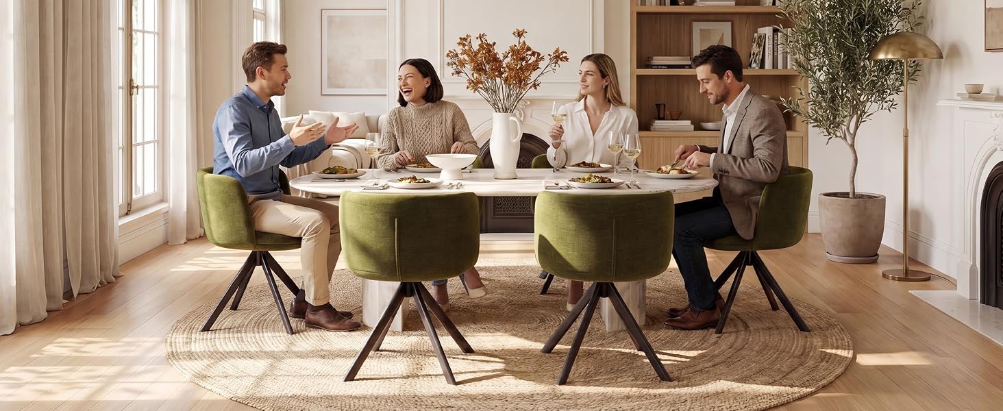 Scena moderna della sala da pranzo con quattro persone sedute al tavolo verde oliva con sedie abbinate, pareti bianche, lampade a sospensione e piante in vaso.