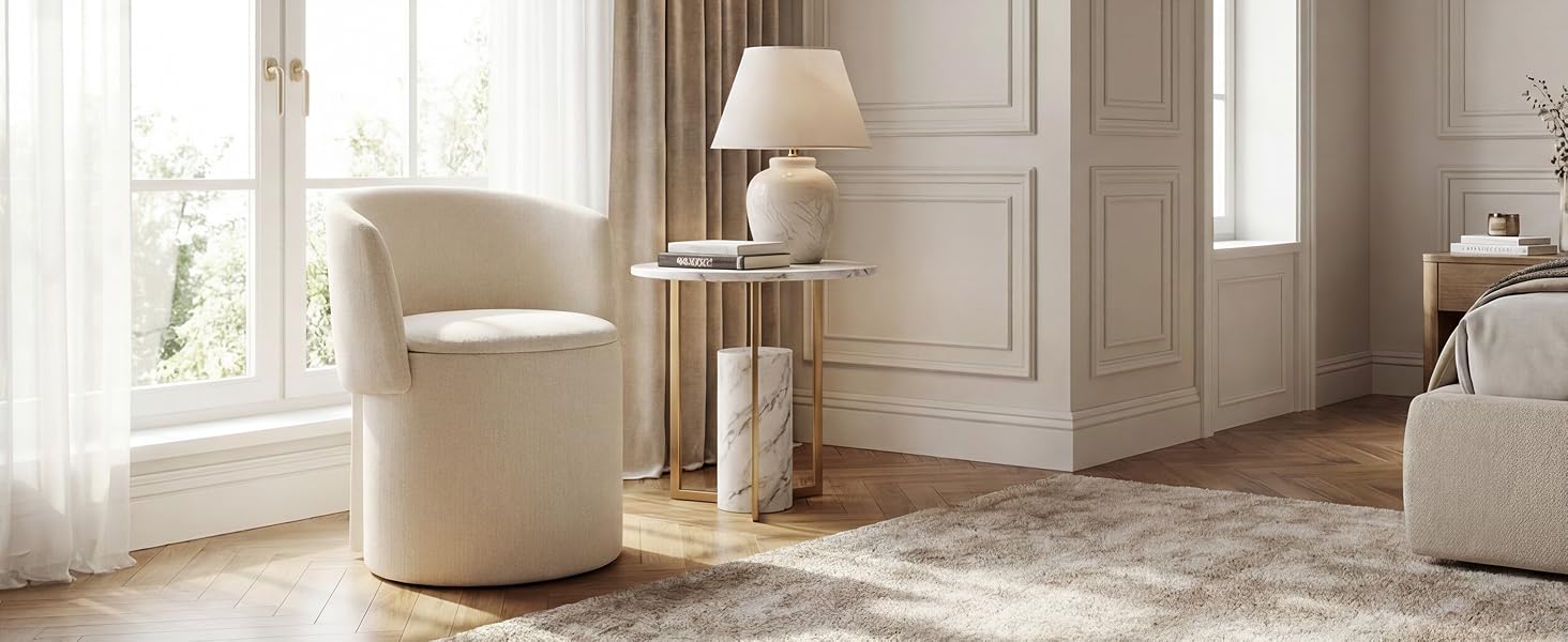 Raffinata ambientazione da soggiorno con sedia a botte beige, tavolino rotondo con lampada da tavolo ed eleganti modanature a parete. Le ampie finestre forniscono illuminazione naturale.
