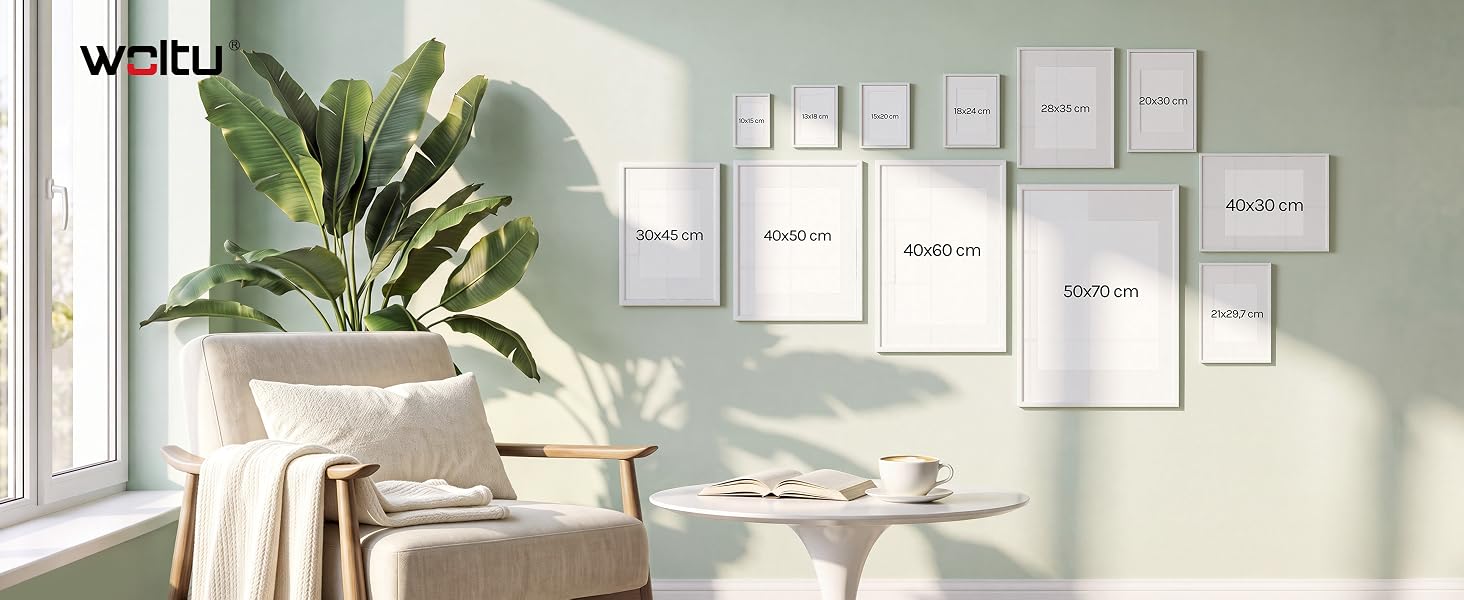 Auf dem Text steht das Markenlogo „Weltu“. Galeriedisplay an der Wand, auf dem mehrere Rahmengrößen asymmetrisch angeordnet sind: 30x40, 40x60, 70x100, 50x70, 40x30 und kleinere A3/A4-Formate. Modernes, minimalistisches Zimmer mit Tageslicht und Pflanzen.